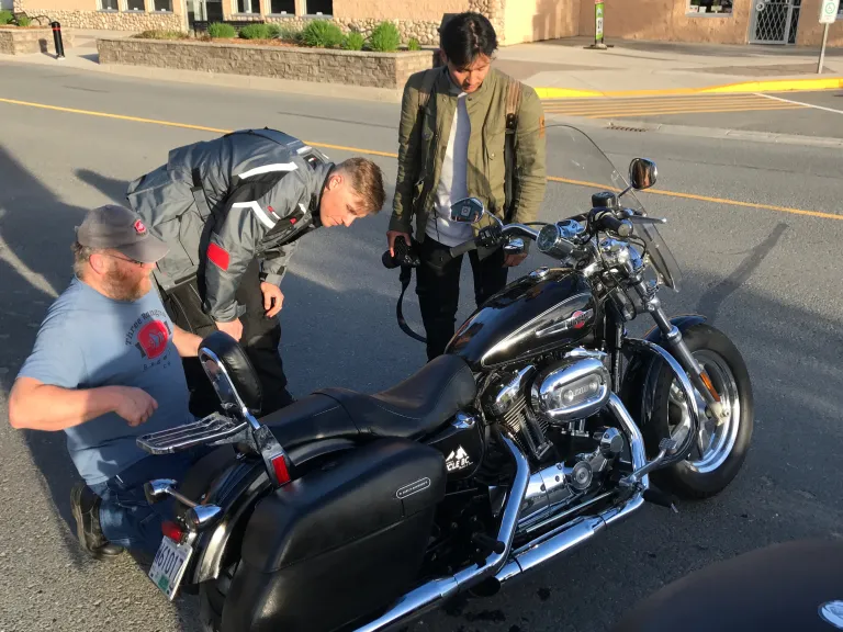 Route 16 riders getting mechanical help for their motorcycle from a Valemount local 