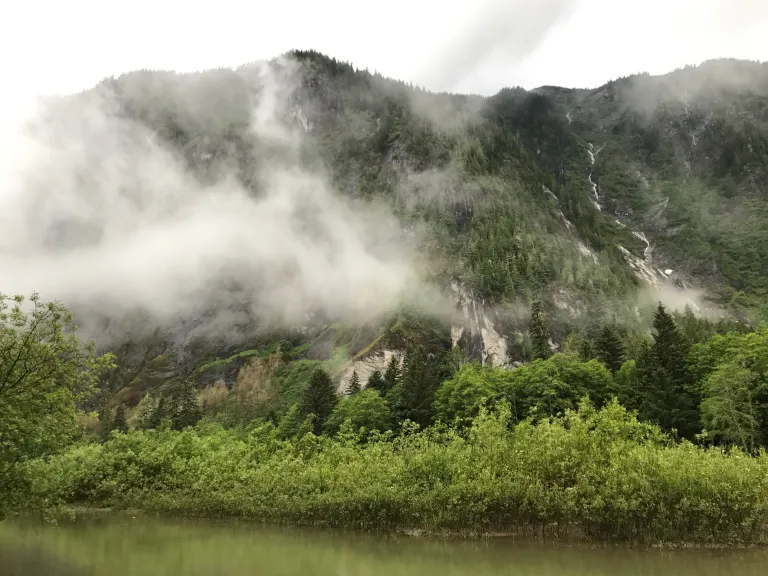 Clouds floating in front of lush green landscapes and mountains in Prince Rupert along Route 16