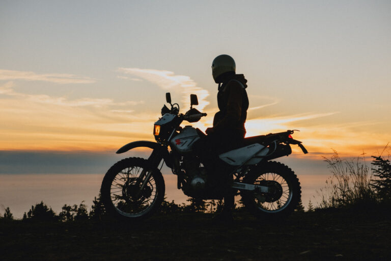 hey kid thumbnail, author steve milum sitting on his bike looking over the ocean at sunset by prince rupert along route 16